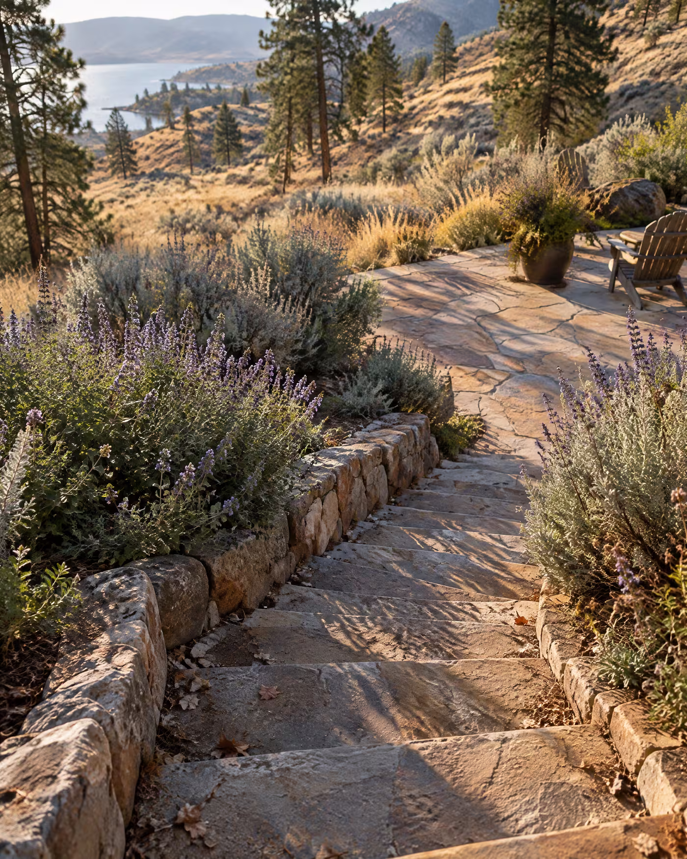 Curved fieldstone steps between beds of sage and catmint leading to a flagstone patio